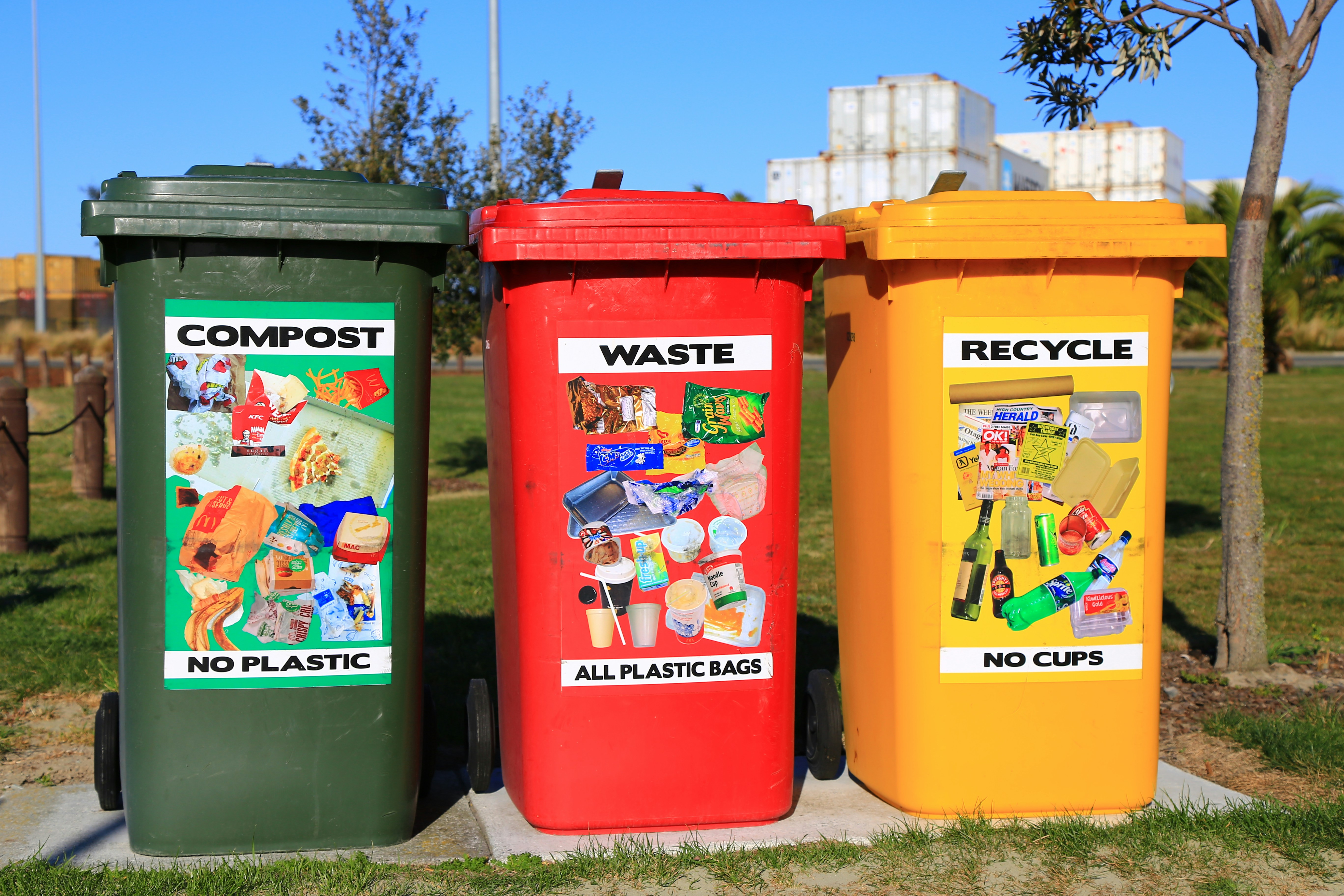 Three bins with compost, waste and recycling labels.