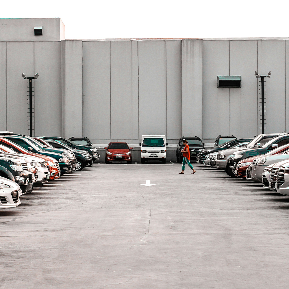 A person walking through a car park